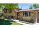 Inviting front entrance with brick accents, a well-maintained lawn, and mature trees at 8272 Ammons Cir, Arvada, CO 80005
