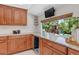 Kitchen with wooden cabinets, granite countertops, and a window overlooking the backyard playset at 8272 Ammons Cir, Arvada, CO 80005
