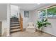 View of staircase with carpeted steps, wooden railing, and a sunlit landing with a comfortable chair at 8272 Ammons Cir, Arvada, CO 80005