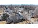 A high angle aerial view showcases houses in a neighborhood with mature trees on a sunny day at 6330 E 13Th Ave, Denver, CO 80220