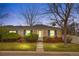 Charming brick ranch home with blue shutters and landscaped front yard at dusk at 6330 E 13Th Ave, Denver, CO 80220