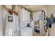 Functional laundry area with washer, dryer, water heater, and storage shelves at 6330 E 13Th Ave, Denver, CO 80220
