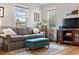Comfortable living room with a gray sofa, wood floors, and large windows providing natural light at 6330 E 13Th Ave, Denver, CO 80220