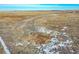 A view of acreage for sale that is mostly brown fields with some patches of snow at 48155 E 56Th Ave, Bennett, CO 80102