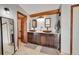 Bathroom with double sinks, granite countertop and wooden beam feature above vanity at 48155 E 56Th Ave, Bennett, CO 80102