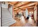Open-concept dining area with exposed wood beams, showcasing rustic elegance with staircase and natural light at 48155 E 56Th Ave, Bennett, CO 80102