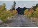 Long driveway leading to a house surrounded by trees with autumn foliage at 48155 E 56Th Ave, Bennett, CO 80102