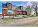 Attractive log home with a quaint porch, set amidst a well-maintained lawn and gravel driveway at 48155 E 56Th Ave, Bennett, CO 80102