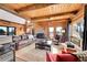 Comfortable living room with rustic accents, a brick fireplace, and expansive windows offering scenic views at 48155 E 56Th Ave, Bennett, CO 80102