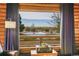 Bright living room with large window framing scenic exterior views, log walls and neutral colored curtains at 48155 E 56Th Ave, Bennett, CO 80102