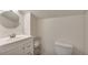 Bright bathroom features a round mirror, white vanity, and toilet, offering a clean aesthetic at 3186 Springmeadow Cir, Castle Rock, CO 80109