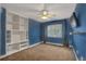 Cozy bedroom with built-in bookcase, carpeted floor, TV, and a window providing natural light at 3186 Springmeadow Cir, Castle Rock, CO 80109