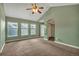 Expansive carpeted bedroom with vaulted ceiling, a fan, windows, and an archway leading to the bathroom at 3186 Springmeadow Cir, Castle Rock, CO 80109