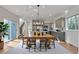 Open-concept dining area featuring a large wooden table, stylish chandelier, and easy access to the kitchen at 3186 Springmeadow Cir, Castle Rock, CO 80109