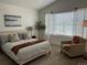 Bright bedroom with a large window, cozy chair, and a comfortable bed, creating a peaceful and relaxing space at 9756 Ash Ln, Thornton, CO 80229