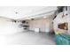Spacious garage with storage shelves, overhead door, and room for multiple vehicles at 9756 Ash Ln, Thornton, CO 80229