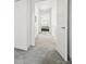 Bright, carpeted hallway with white walls, creating a clean and modern transition between living spaces at 9756 Ash Ln, Thornton, CO 80229