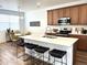 Modern kitchen with stainless steel appliances, a spacious island, and sleek countertops, perfect for cooking at 9756 Ash Ln, Thornton, CO 80229