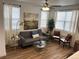 Bright living room with hardwood floors, modern furniture, and large windows for plenty of natural light at 9756 Ash Ln, Thornton, CO 80229