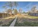 Spacious backyard featuring a concrete path, wooden fence, and mature trees at 1364 Lansing St, Aurora, CO 80010