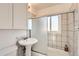 Bathroom featuring a pedestal sink, updated vanity mirror and cabinet, and tiled shower with glass door at 1364 Lansing St, Aurora, CO 80010