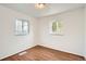 Simple bedroom with wood-look flooring and two bright windows showing neighborhood view at 1364 Lansing St, Aurora, CO 80010