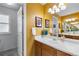 Bathroom featuring a sink, decorative art, large mirror, and a neutral countertop with wood cabinets at 2231 E 128Th Ave, Thornton, CO 80241