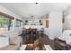 Open concept living and dining area with hardwood floors, bright windows, and a modern chandelier at 2231 E 128Th Ave, Thornton, CO 80241