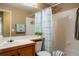 Cozy bathroom with wood cabinets, shower with geometric curtain, and bright neutral paint at 4873 Eckert St, Castle Rock, CO 80104