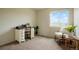 Bright bedroom with a white vanity, desk, comfortable seating and a large window showcasing a clear blue sky at 4873 Eckert St, Castle Rock, CO 80104