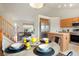 View of kitchen and living room from dining area, featuring a round table and wood laminate flooring at 4873 Eckert St, Castle Rock, CO 80104