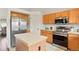 A view of the kitchen with stainless steel refrigerator, tile countertops, wooden cabinets, and tile floors at 4873 Eckert St, Castle Rock, CO 80104