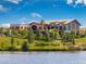 A beautiful clubhouse overlooking a serene lake with manicured landscaping and inviting play structures at 15994 La Plata Peak Pl, Broomfield, CO 80023