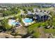 Aerial view of a resort-style pool with a slide, surrounded by mature trees and landscaping at 15994 La Plata Peak Pl, Broomfield, CO 80023
