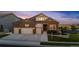 Inviting brick and siding home featuring a three-car garage, manicured lawn, and a cozy, well-lit entrance at 15994 La Plata Peak Pl, Broomfield, CO 80023