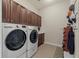 Functional laundry room featuring a washer, dryer, storage cabinets, tile flooring, and integrated organizational system at 15994 La Plata Peak Pl, Broomfield, CO 80023
