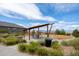A picnic table under a modern pergola, surrounded by lush landscaping and a playground at 15994 La Plata Peak Pl, Broomfield, CO 80023