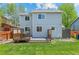 Home back view featuring a wood deck, a well-maintained yard, and light-blue siding at 13245 Shoshone St, Denver, CO 80234
