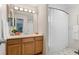 This bathroom features a wood vanity, ample lighting, and a shower with a patterned curtain at 13245 Shoshone St, Denver, CO 80234