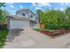 Inviting two-story home with a manicured lawn, a porch, and an attached two-car garage at 13245 Shoshone St, Denver, CO 80234