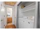 Convenient laundry area includes a washer, dryer, shelving, and a door that leads to the bathroom at 13245 Shoshone St, Denver, CO 80234