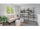 Relaxing living room has a cream sofa, ottomans, and a shelf to display books and plants at 13245 Shoshone St, Denver, CO 80234