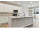 Modern kitchen with white cabinets, a large center island, and stainless steel appliances at 18308 Martinello Dr, Parker, CO 80134