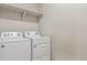 Laundry room featuring modern washing machine and dryer and storage shelving at 18308 Martinello Dr, Parker, CO 80134