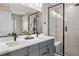 Modern bathroom featuring dual sinks, white countertops, and a glass-enclosed shower at 14096 Red Cosmos St, Parker, CO 80134