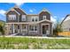 Charming townhome featuring a covered front porch, manicured lawn and neutral two-tone color scheme at 14096 Red Cosmos St, Parker, CO 80134