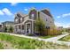 Side view of a charming townhome featuring a covered front porch, manicured lawn and neutral color scheme at 14096 Red Cosmos St, Parker, CO 80134