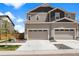 Charming two-story home with tan and brown siding, two-car garage, landscaping, and sidewalk at 14096 Red Cosmos St, Parker, CO 80134
