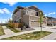 Charming two-story home with tan and brown siding, two-car garage, landscaping, and sidewalk at 14096 Red Cosmos St, Parker, CO 80134