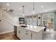 Bright kitchen island with seating, seamless flow into the living and dining areas, and stainless steel appliances at 14096 Red Cosmos St, Parker, CO 80134